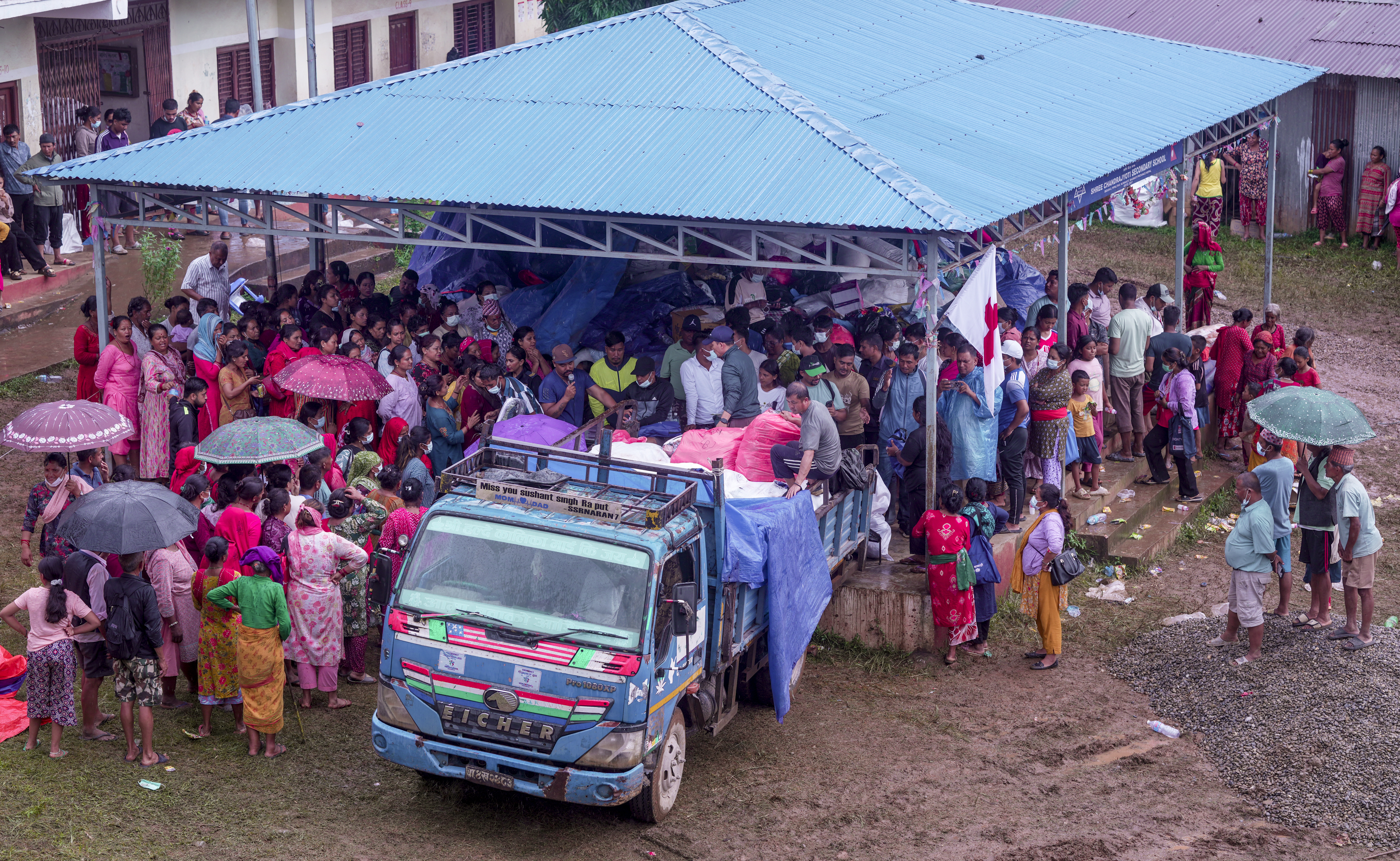 Nuwakot: Flood-affected residents from Devighat gather to receive emergency relief materials being unloaded from a truck at a school turned into a temporary shelter home, in Nuwakot district, Nepal, Friday, Sept. 4, 2026. The region suffered extensive destruction from flash floods and mudslides caused by a high-altitude glacier collapse in late August. (PTI Photo/Karma Bhutia)(PTI09_04_2026_000240B)